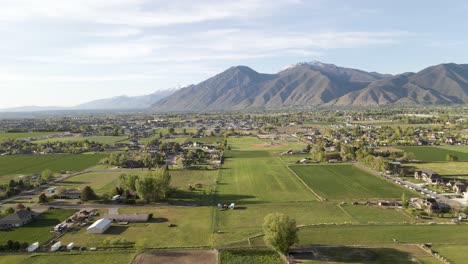 aerial - the wasatch mountains and farmland in mapleton, utah, wide shot