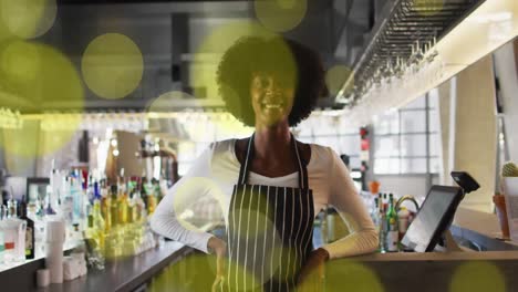 Animation-of-spots-over-african-american-female-worker-in-shop