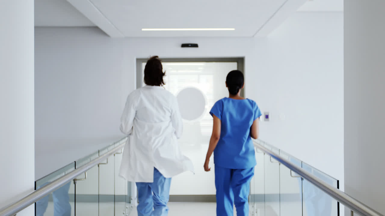 Doctor and nurse running in passageway of hospital
