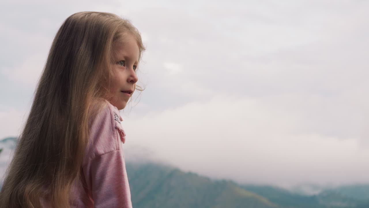 chica feliz mira a las montañas fogosas distantes en las tierras altas