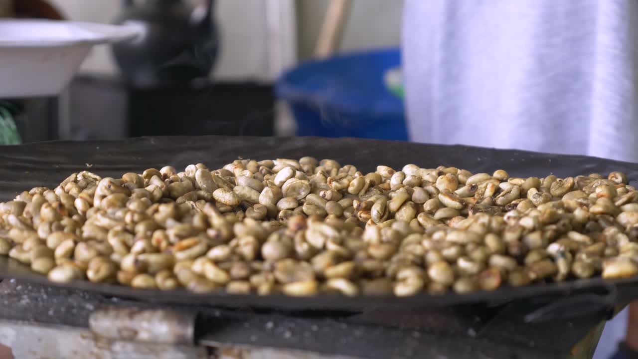 Close shot to the not ready coffee beans being roasted to turn into the national delicious drink, in Ethiopia