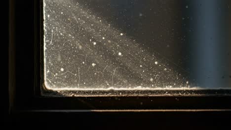 a close-up exploration of dust accumulation on a window pane, highlighting light reflections and intricate details captured in two frames