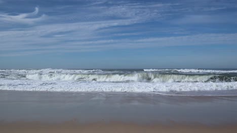 Surf-Golpeando-La-Playa-En-Portugal-Con-Gorras-Blancas-Y-Mares-Agitados