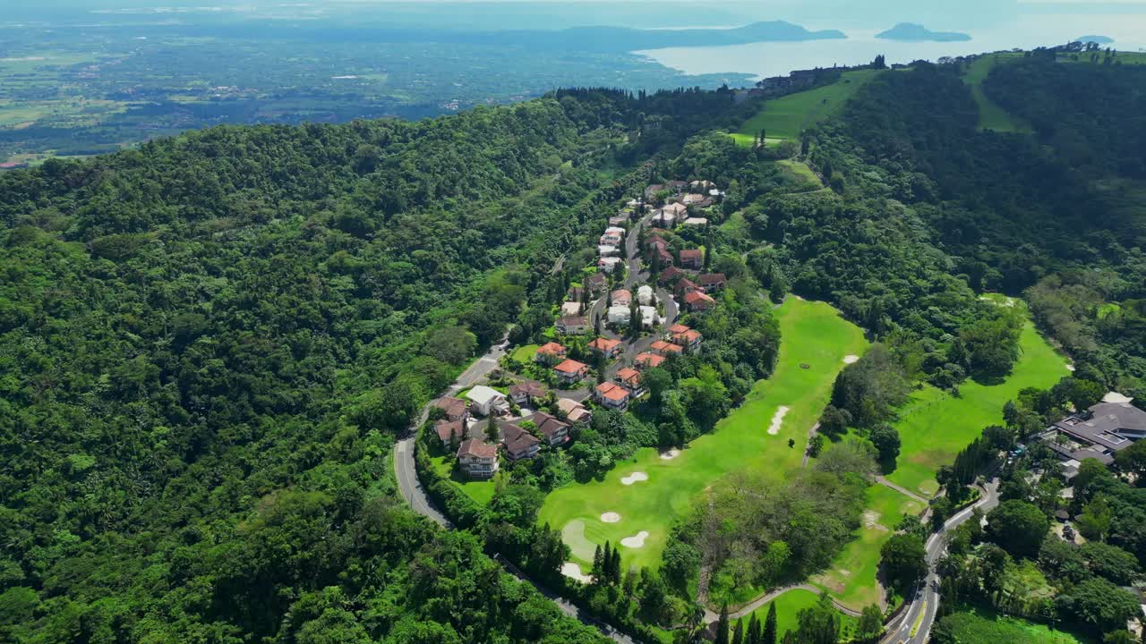 An aerial view of villas in Tagaytay Highlands surrounded by pine trees, winding roads, and forested hills in Batangas, Philippines