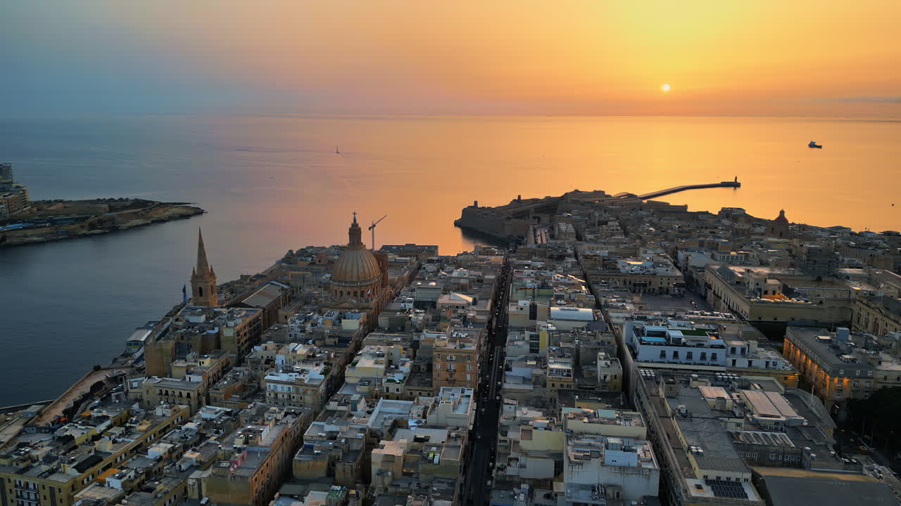 Aerial drone view of the walled city of Valletta, Malta, surrounded by the Mediterranean sea in the evening