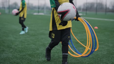 a children's football team trains at the stadium under the guidance of a coach. kids in sports uniforms practice ball exercises, improve technique, and develop teamwork on the green field