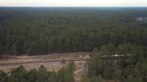 aéreo: el tren se detiene en una estación de tren remota y aislada en medio del bosque
