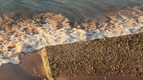 las olas del mar golpean suavemente contra estructuras cúbicas de hormigón erigidas a lo largo de la costa para evitar la erosión, situadas en españa.