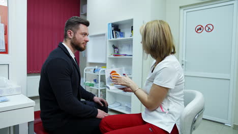 doctor and client talking in ophthalmological office. professional optician giving advice to a male patient on an eye dummy using lenses.