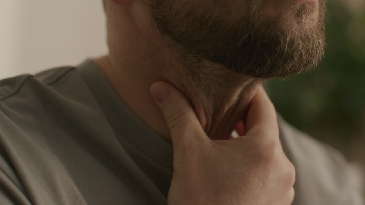 Primo piano di un uomo che si tocca la gola a causa di un fastidio