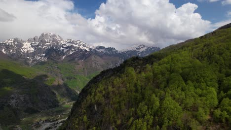 valle de theth que aparece después de un bosque verde en las altas montañas de los alpes de albania