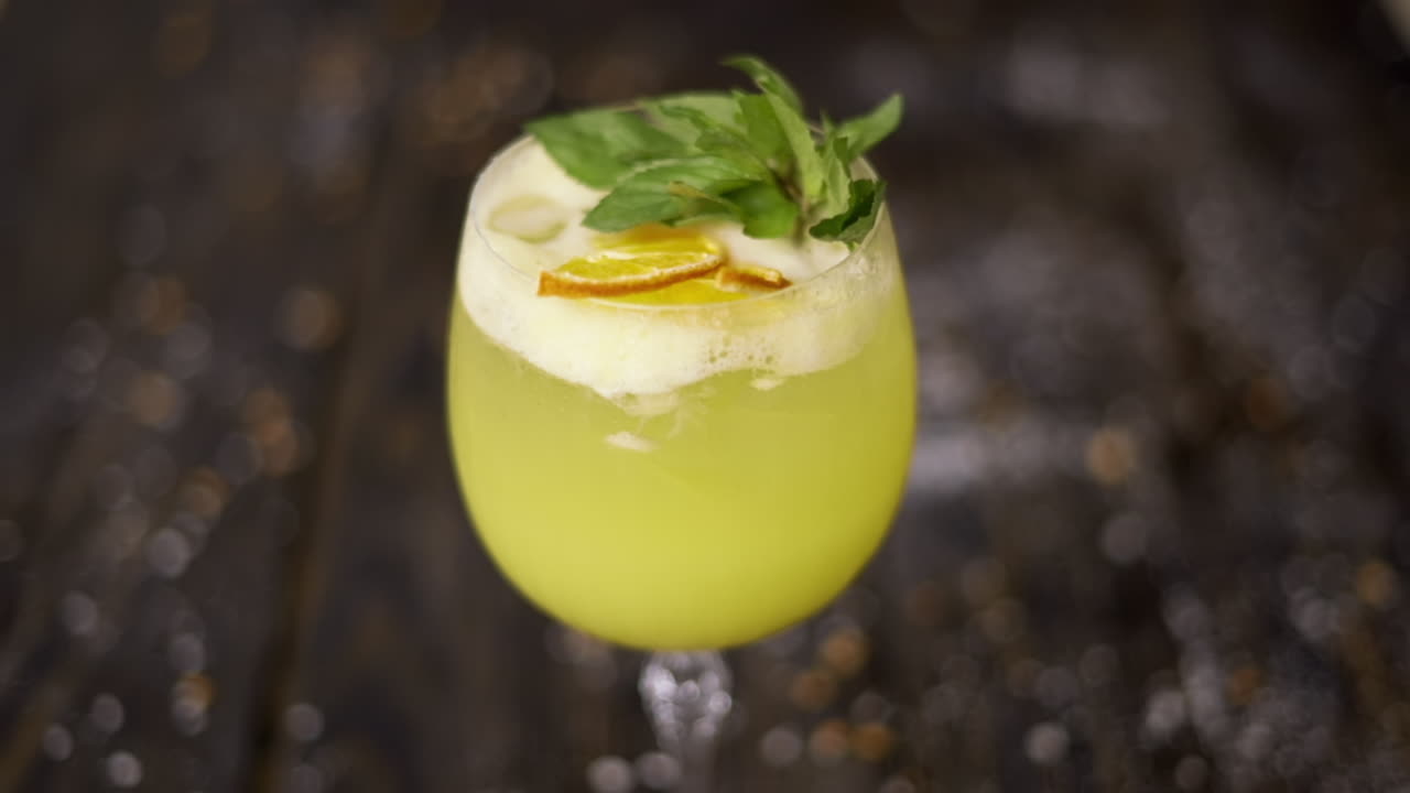 Et glas gul lemonade med mynte på en træoverflade