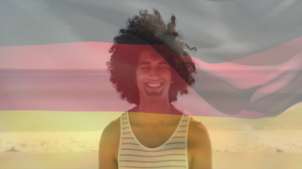 Male subject standing on beach, striped flag sweeping across face, shifting to smile for marketing