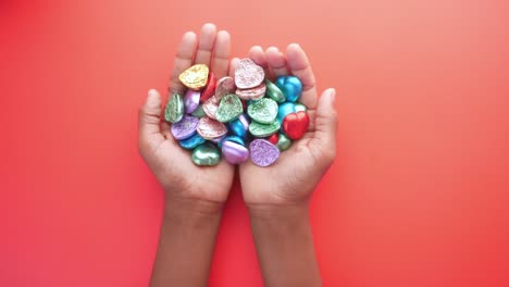 colorful heart-shaped chocolates in hands