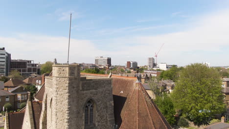 ancient stone church in living district of kingston upon thames, aerial fly over view