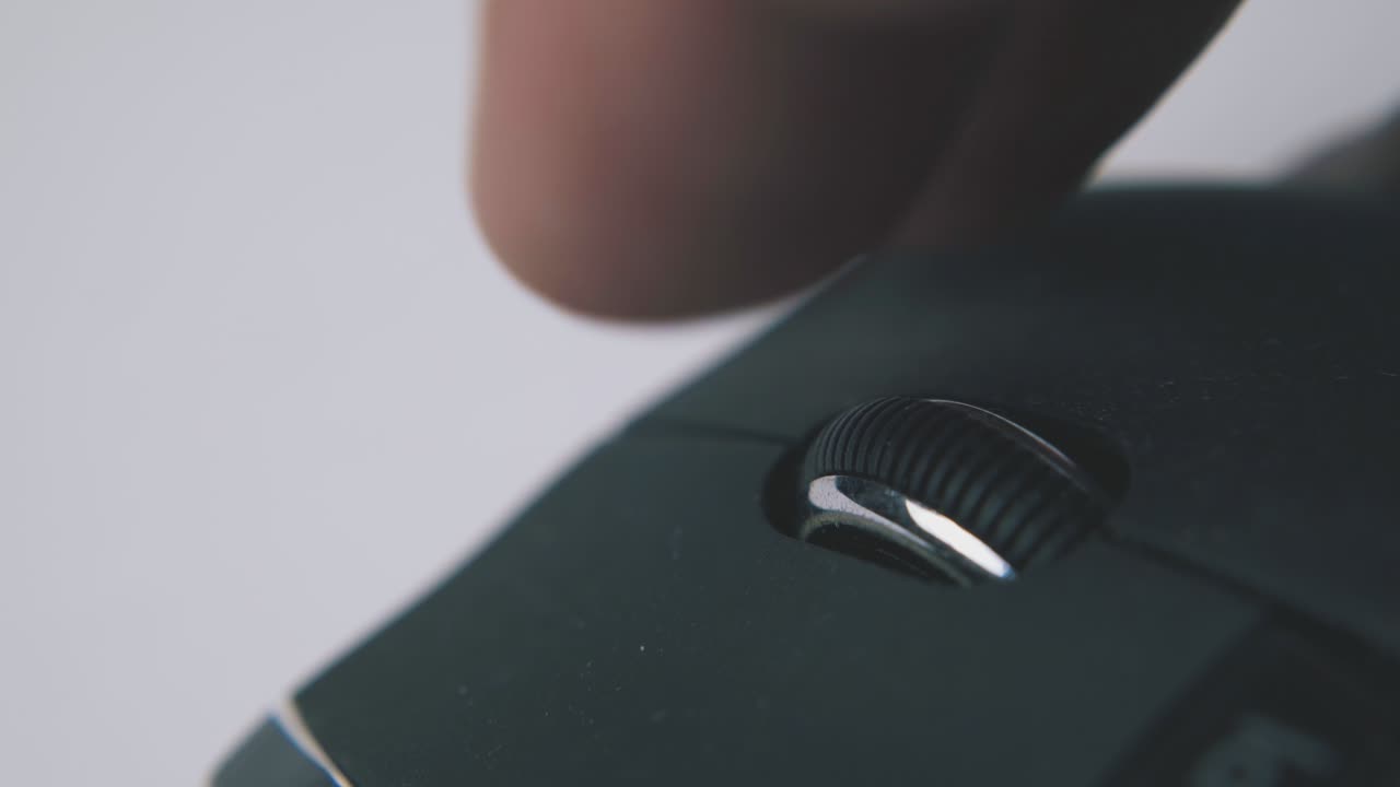 uomo rotola la ruota del mouse del computer su superficie bianca