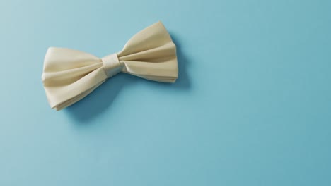 Video-of-yellow-bow-tie-lying-on-blue-background