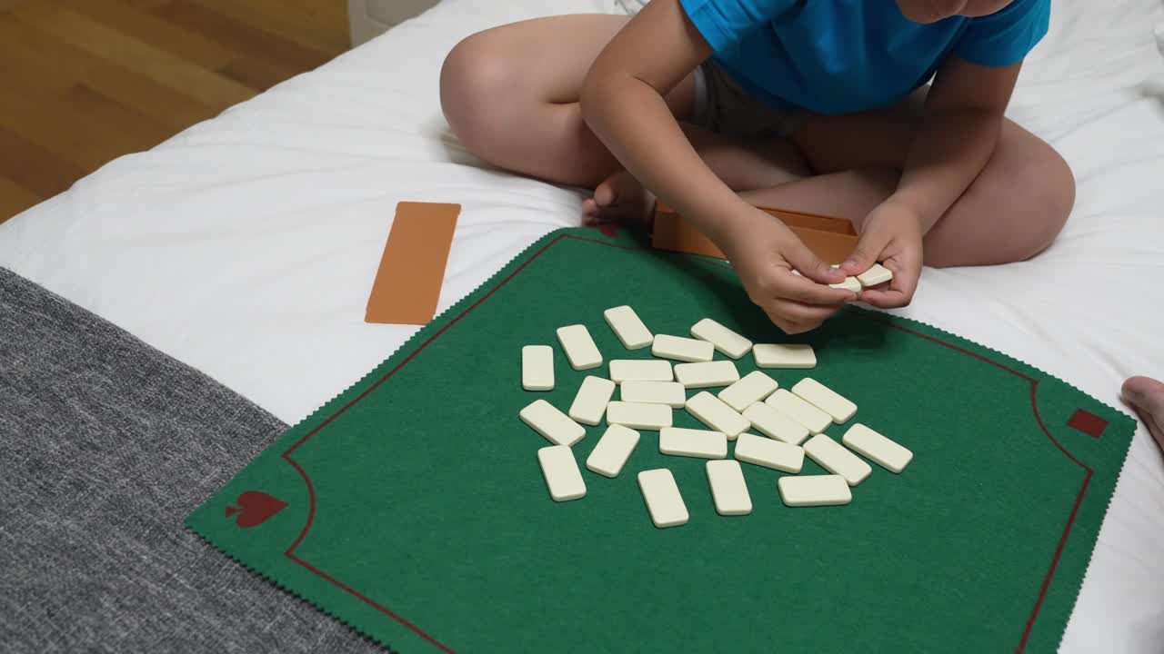 Menino jogando dominó na cama