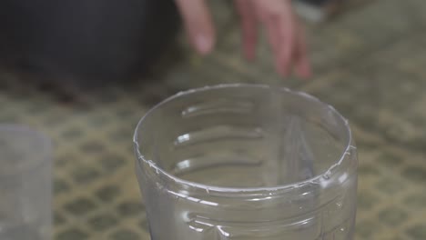 pouring wood finish into plastic container