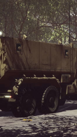 military truck driving on a road through a forest