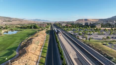 establishing aerial shot of two frontrunner commuter trains at lehi station in utah, usa