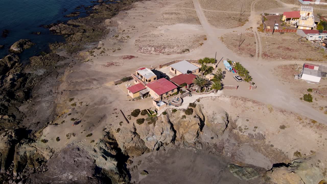 Aerial slow orbit around Mexican coastal villa house on top of sea cliff