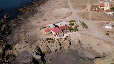 aerial slow orbit around mexican coastal villa house on top of sea cliff