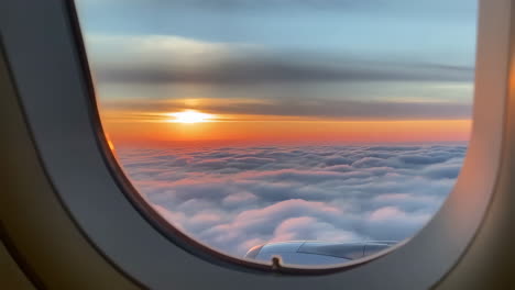 Stunning Sunset View from an Airplane Window Above the Clouds