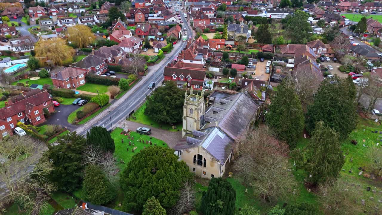 Ripresa aerea panoramica con drone sulla periferia di Southampton con le abitazioni del villaggio di Botley al tramonto in una nuvolosa e coperta giornata invernale, con auto che passano sulle strade sottostanti oltre le piccole case del paese.