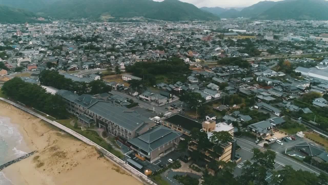 Aerial view of a coastal city with mountains and beach