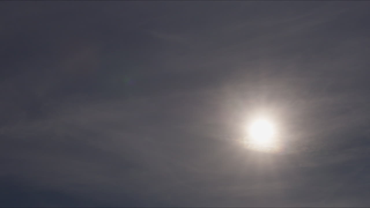 Airplane in the Cloudy Sky with Sun