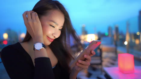 close up of happy asian female scrolling messages on her smarphone