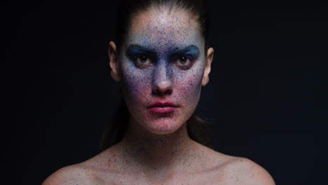 portrait beautiful woman wearing blue face paint makeup looking up exotic body art on attractive female performer creative expression light fading in dark background