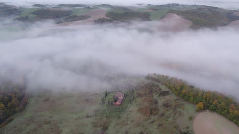 pintoresco edificio de granja rural en el campo de la toscana con niebla matutina, disparo de avión no tripulado