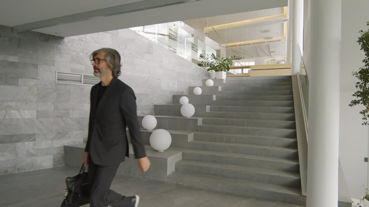 Businessman walking down modern stairs in an office building