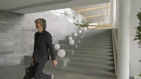businessman walking down modern stairs in an office building