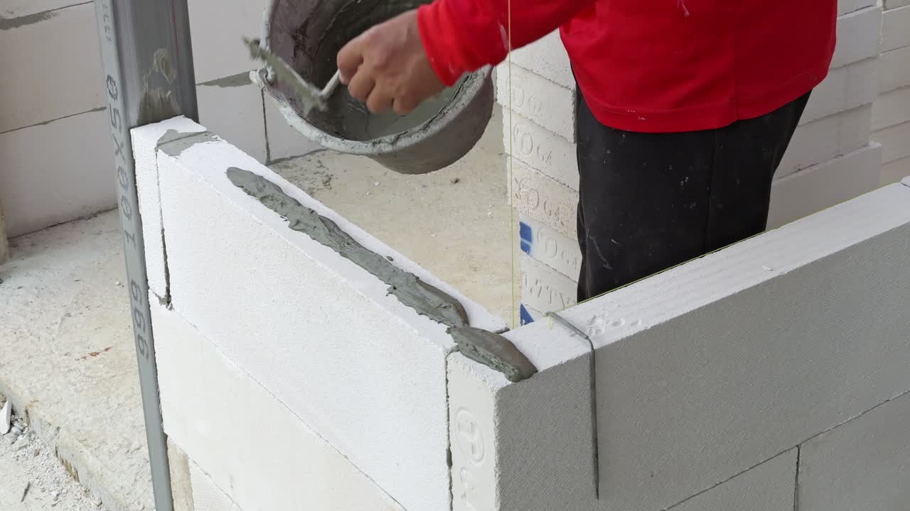 A construction worker skillfully applies mortar walls showcasing essential building techniques in an urban site