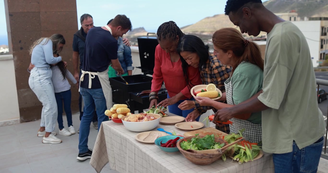 Glad, mangfoldig gruppe venner og familie griller på takterrasse
