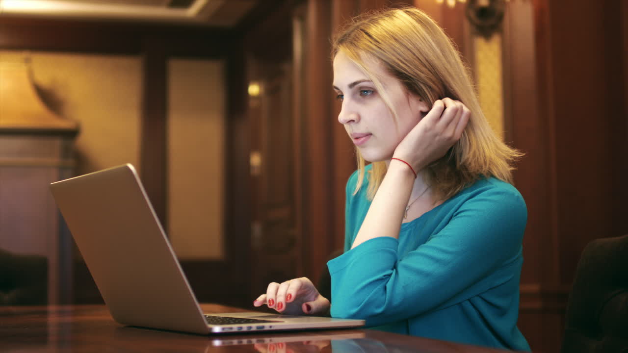 Young woman looking on screen laptop and typing on keyboard