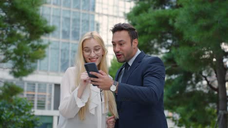 man and woman winning on mobile phone with virtual business investment, news or profit, excited face expressions of business couple traders for profit, sales or bonus