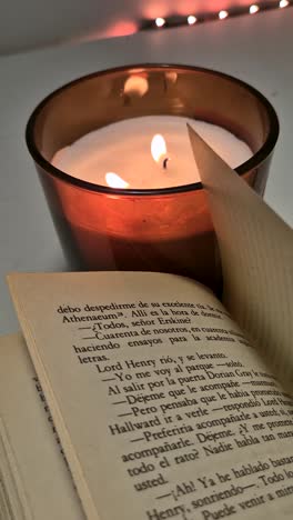 aesthetic view of candle beside an open book