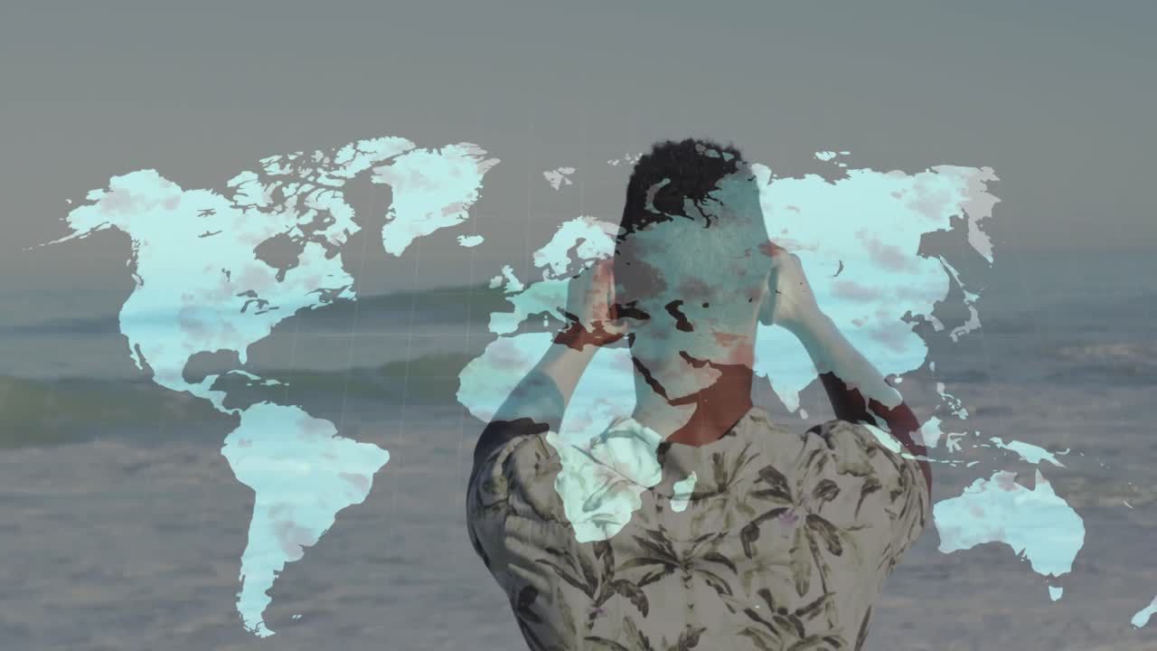 아프리카계 미국인 남자가 해변에서 스마트폰으로 사진을 찍고 있는 세계 지도