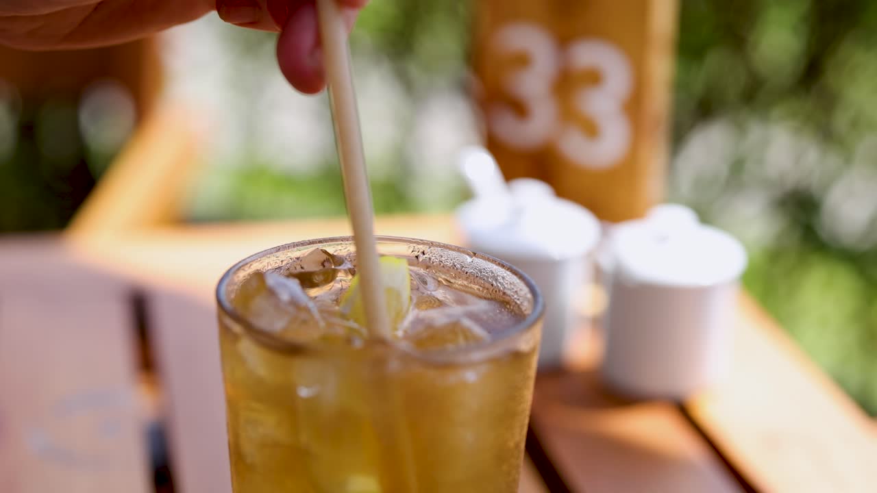 손은 빛이 비치는 테이블 위에 얼음으로 차가운 음료를 어서 상쾌하고 활기찬 장면을 만니다.