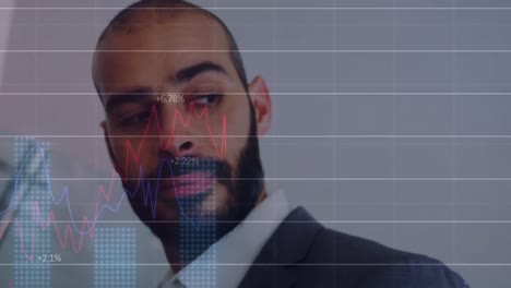 financiële gegevensverwerking tegen biracial zakenman glimlachend op kantoor