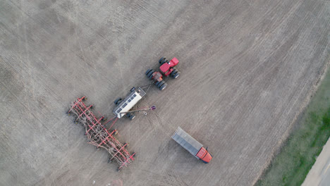 topdown of farm tractor seeding crops at agricultural field in saskatchewan, canada