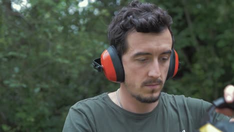 young caucasian man puts on safety visor and headphones slow motion