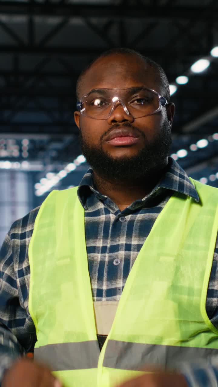 Vertical Video Engineer in safety hi vis vest uses tools in a fabrication workshop