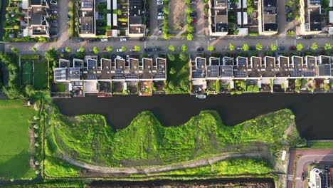 Weesp-residential-development-on-waterways-with-lush-natural-vegetation,-aerial