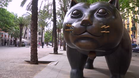 una gran escultura de un gato se encuentra a lo largo de una calle en barcelona españa