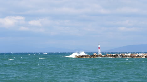 slowmotion waves hitting and splashing water over breakwater in greece